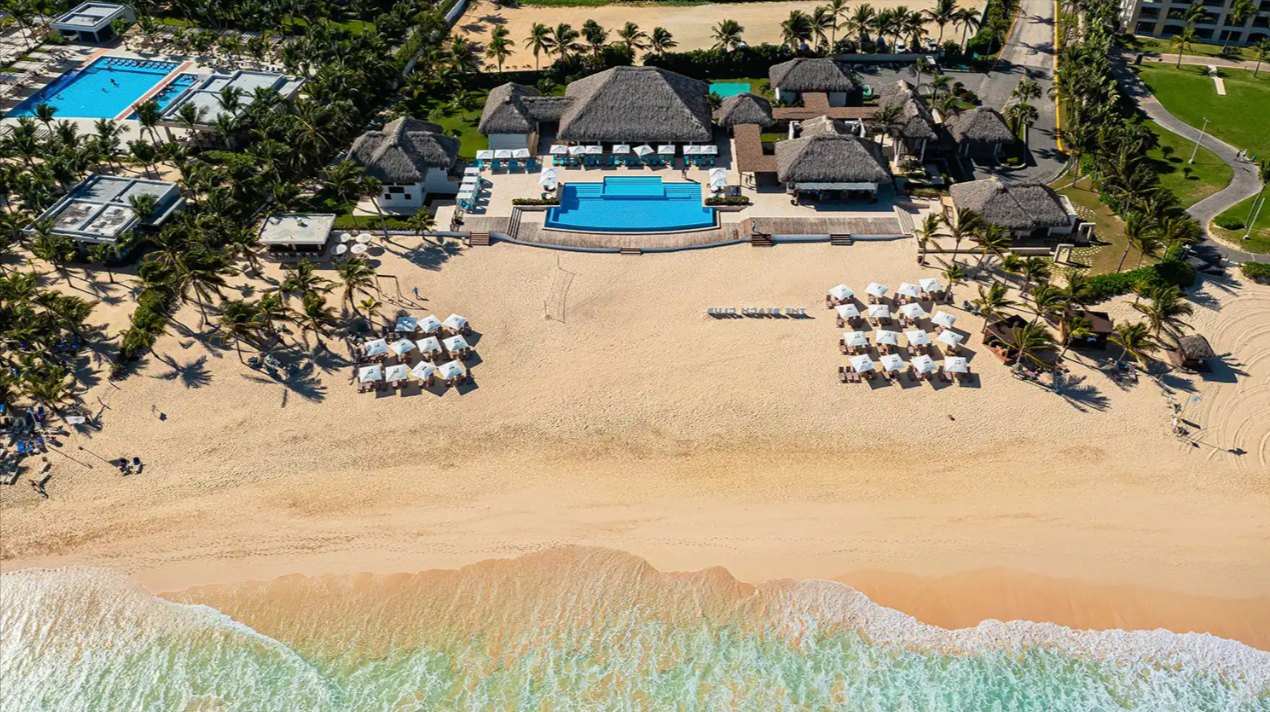 Aerial photograph of surf breaking on the sand at the Cana Bay beach club, about 5 minutes from Poseidonia; it shows the community's beach, not the development.
